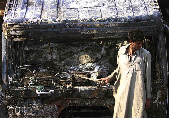 Pakistan tankers attack: 4 October: A Pakistani driver stands beside an oil tanker