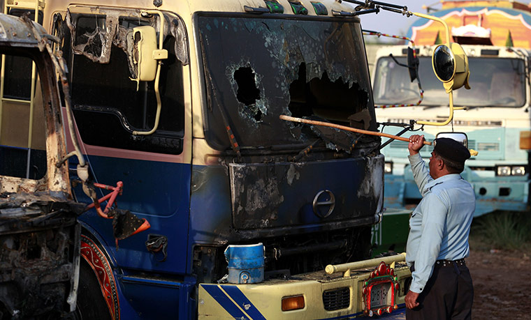Pakistan tankers attack: 4 October: A policeman looks at a burnt out oil tanker carrying fuel 