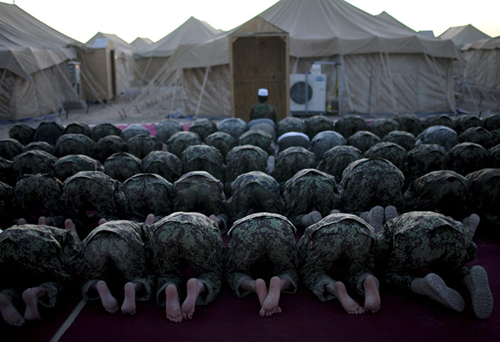 24hours: Afghan soldiers pray at  dusk  at Forward Operation Base Howz-