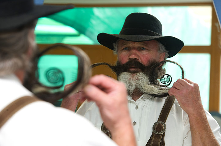 Beard championships: Manfred Richter from Germany looks into a mirror while styling his beard 
