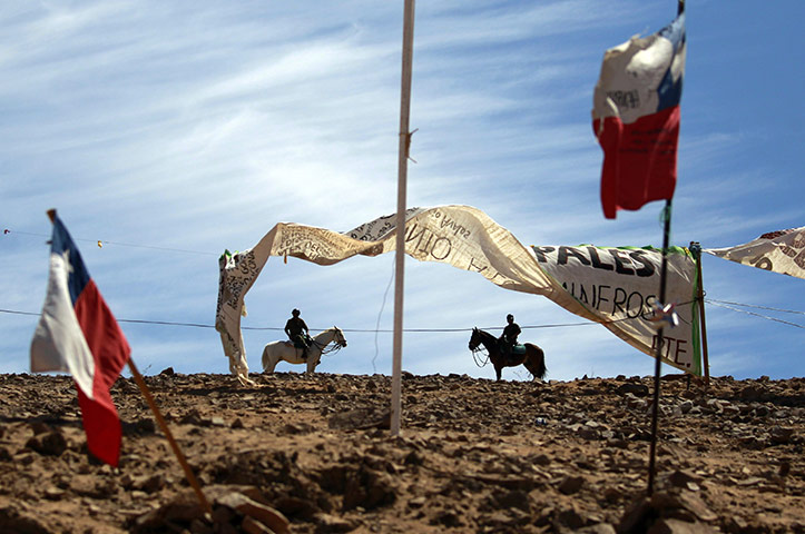 Chile miners rescue: 5 October: Police on horseback patrol near Chilean flags