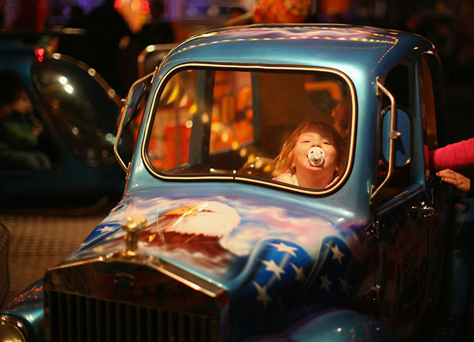 24 hours in pictures: A young girl enjoys a childrens ride at the fair ground, Nottingham