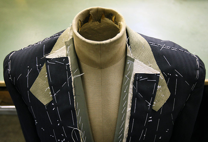 Week in Business: A partially finished suit hangs in bespoke tailoring rooms