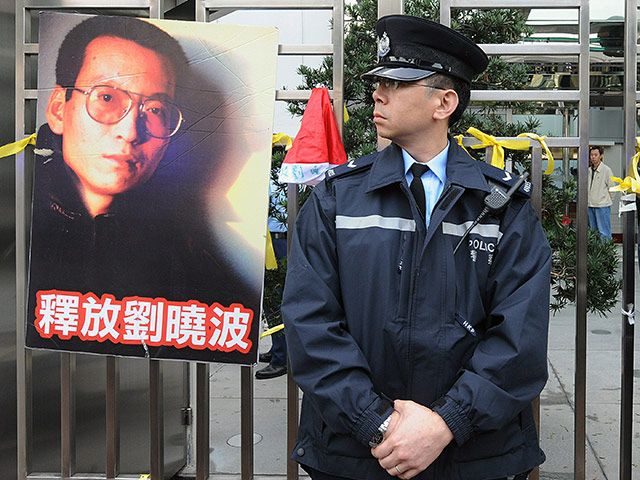 Liu Xiaobo Nobel Peace: A policeman standing next to a poster showing Chinese dissident Liu Xiaobo