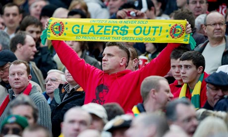 Manchester United fan holds up anti-Glazer scarf