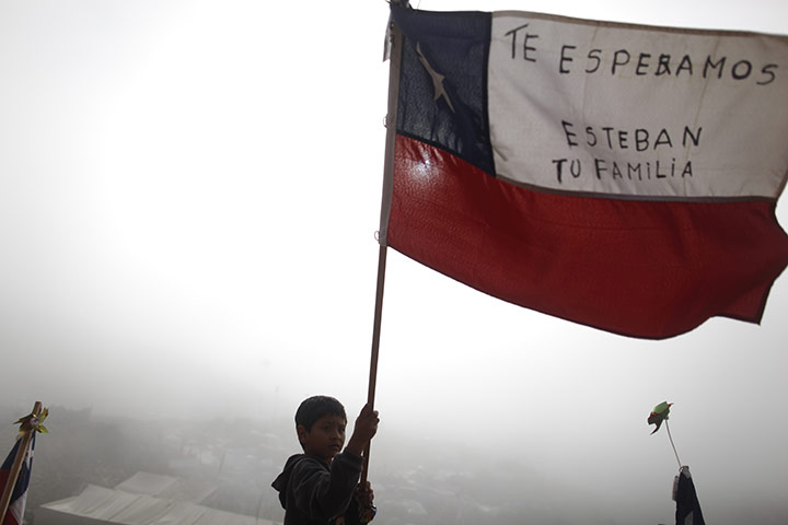 Chile Miners Rescue: A boy waves a Chilean flag after a drill reached the trapped miners