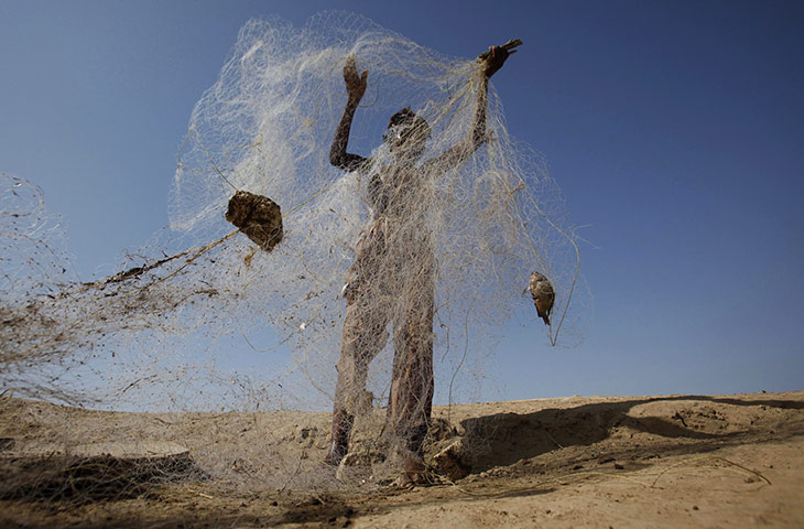 24 hours in pictures: A flood victim cleans his fishing net