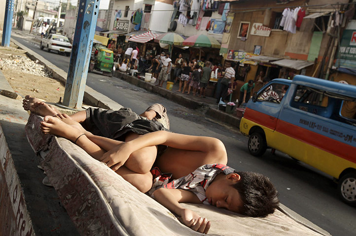 24 hours in pictures: Filipino informal settler children sleep on a side street in Pasay city