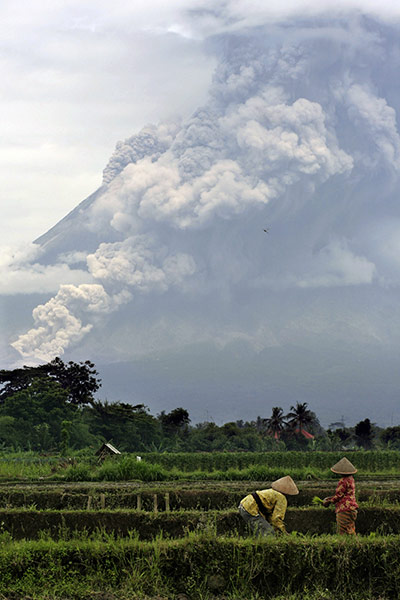 Mount Merapi: Farmers work on a field as Mount Merapi 