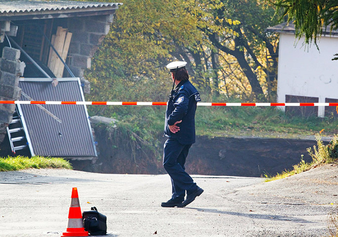 Germany sinkhole: A member of the emergeny services works at the scene