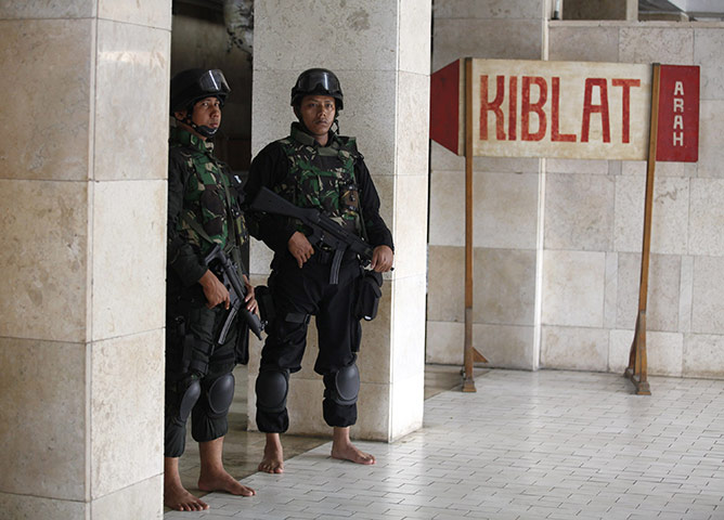 Obama in Indonesia: Barefoot Indonesian troops stand next to a sign