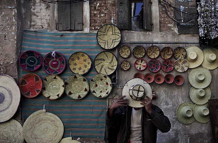 24 hours in pictures: San'a, Yemen: A man tries a hat on at a market