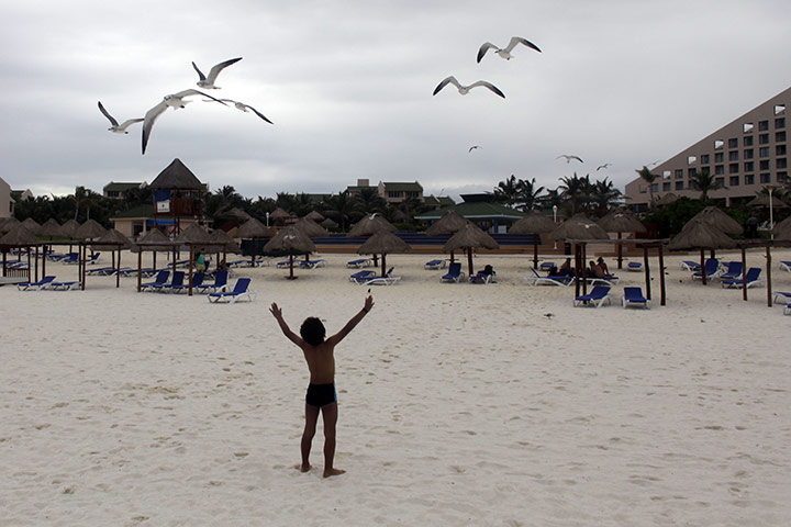 24 hours in pictures: a child plays on the beach in Cancun, Mexico