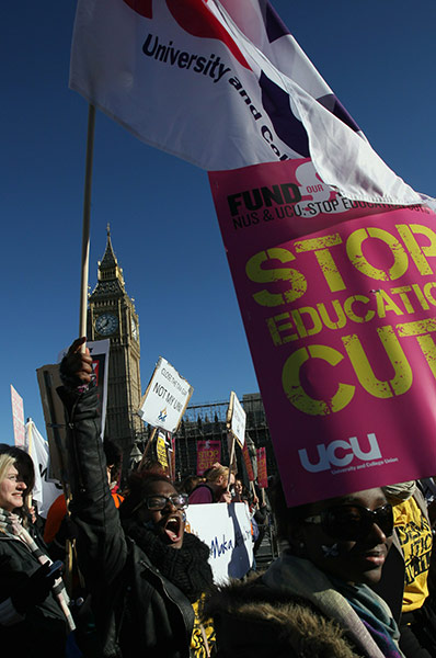 Students protest: Students hold placards as they march past the Houses of Parliament, London