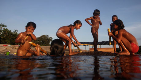 Children from Bare tribe play and eat sugar cane on the Negro River in northern Brazil