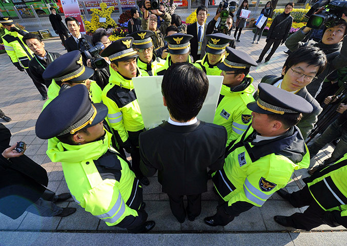 G20 Seoul: A South Korean protestor is surrounded by policemen
