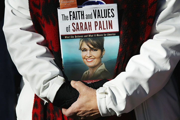 Week in Business: A Tea Party supporter holds a Sarah Palin book 