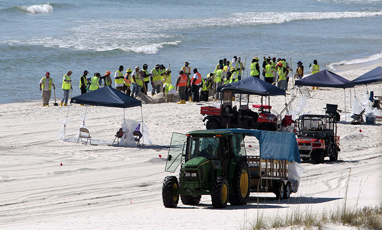 Week in Business: Oil spill workers continue the process of cleaning beaches in Alabama