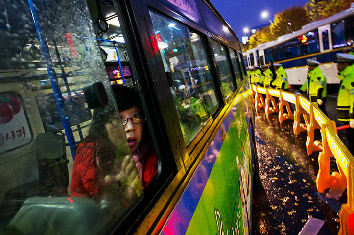 24 hours in pictures: A commuter looks out of a bus during a protest at the 2010 G20 Summit