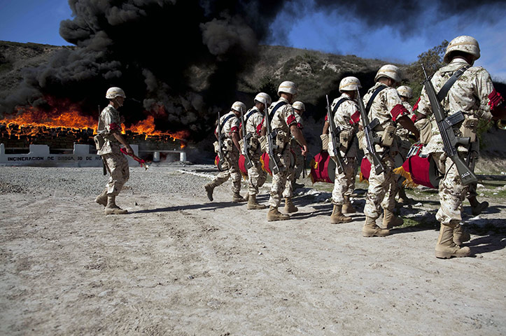 24 hours in pictures: Soldiers walk while packages of marijuana are being incinerated