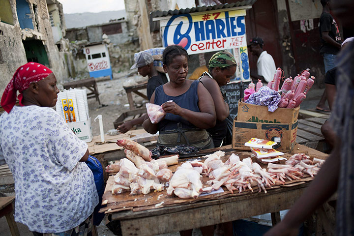 Cholera in Haiti: A sales woman packs a piece of meat from a street cart in Haiti