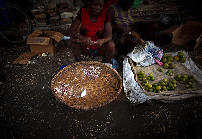 Cholera in Haiti: Haitian women wait for customers as they sell fish in Port-au-Prince