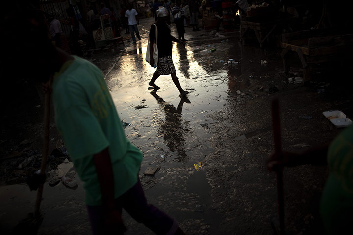 Cholera in Haiti: A woman crosses a street covered with dirty water in Port-au-Prince, Haiti