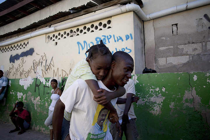 Cholera in Haiti: A man carries a girl who presents cholera symptoms in Port au Prince