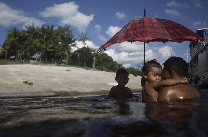 From the agencies: Bare tribe man swims with his children in Santa Isabel do Rio Negro