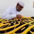 Hajj In Mecca: A Saudi worker sews Islamic calligraphy on a drape in Mecca