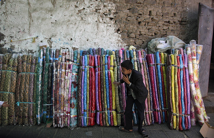 24 Hours: A Yemeni boy selling bed sheets in an alley of the old city