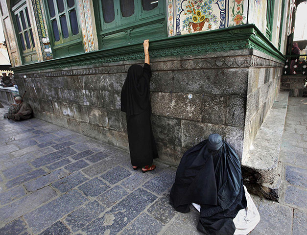 24 Hours: A Kashmiri Muslim woman prays for alms in Srinagar