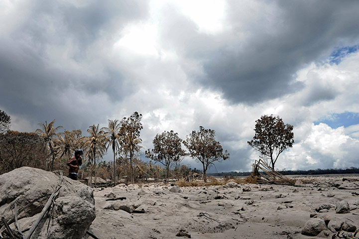 24 hours: A villager walks on volcanic ash and debris from the Mount Merapi eruption