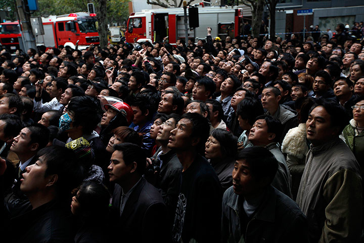 Shanghai fire: a crowd of people watch the burning building