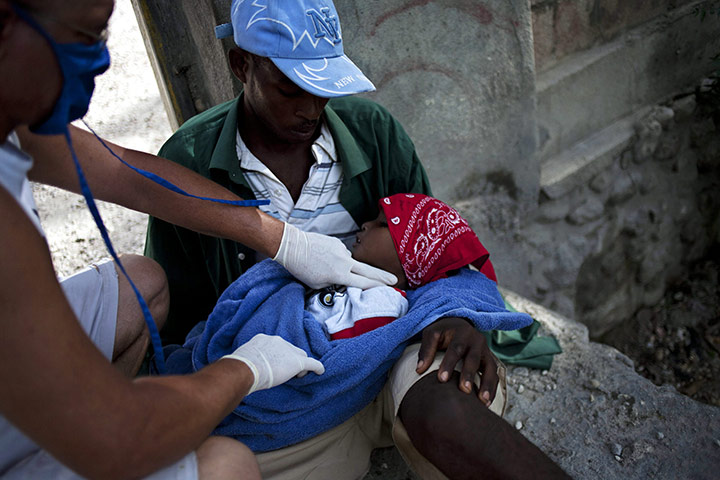 Haiti cholera: A Cuban doctor checks the vital signs of a boy suffering cholera symptoms