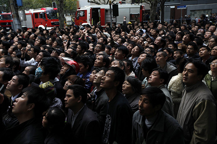 24 hours in pictures: People watch a burning building in Shanghai