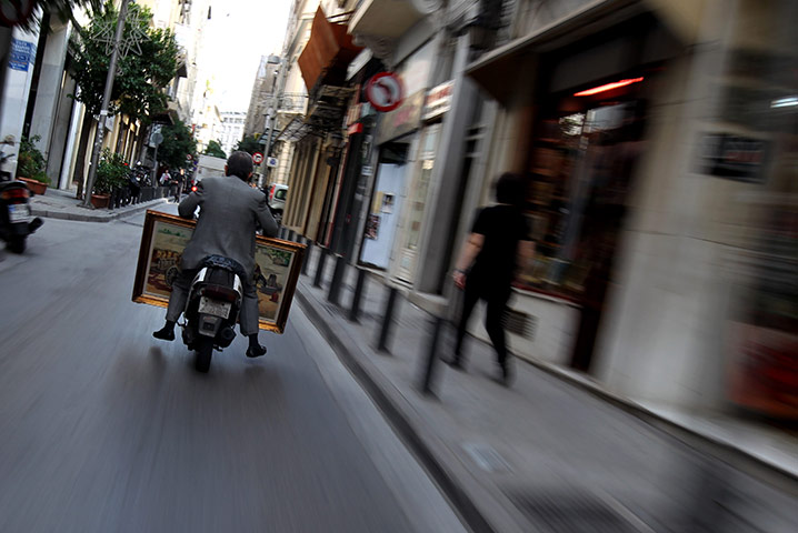 24 hours in pictures: man on a scooter in athens