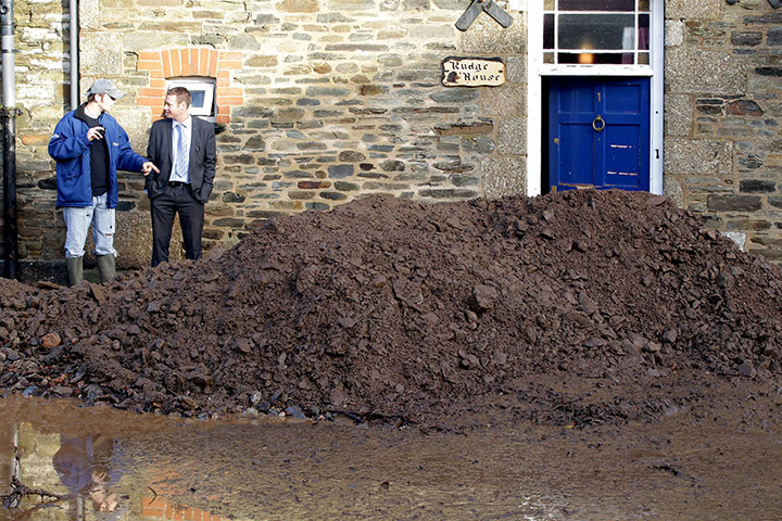 cornwall flooding: Residents look at the silt washed down a street in Lostwithiel