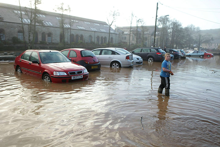 cornwall flooding: Early morning walker navigate flood water in Lostwithiel