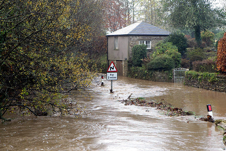 cornwall flooding: Flood water gushes down a road outside Lostwithiel