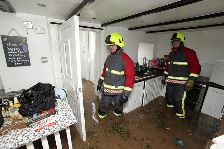 cornwall flooding update: Firemen clear a flooded house in St Blazey