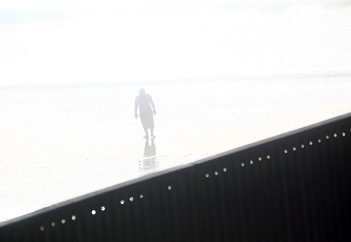 Eric Thayer : A man walks near a wall separating Mexico and the US in Tijuana, Mexico