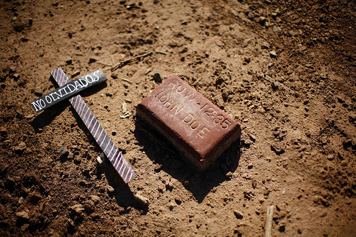 Eric Thayer : A cross that reads Not Forgotten lies next to an anonymous grave