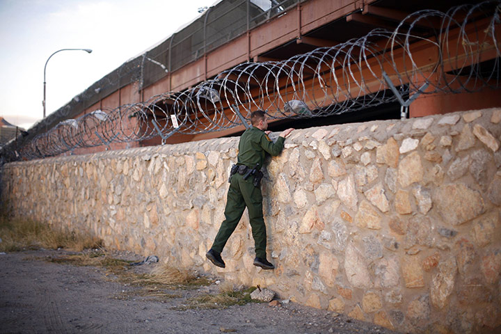 Eric Thayer : A United States Border Patrol agent checks an area under a bridge crossing