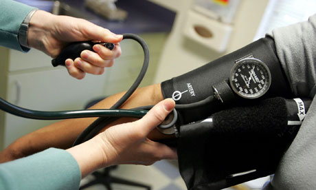 A doctor gauges a patient's blood pressure