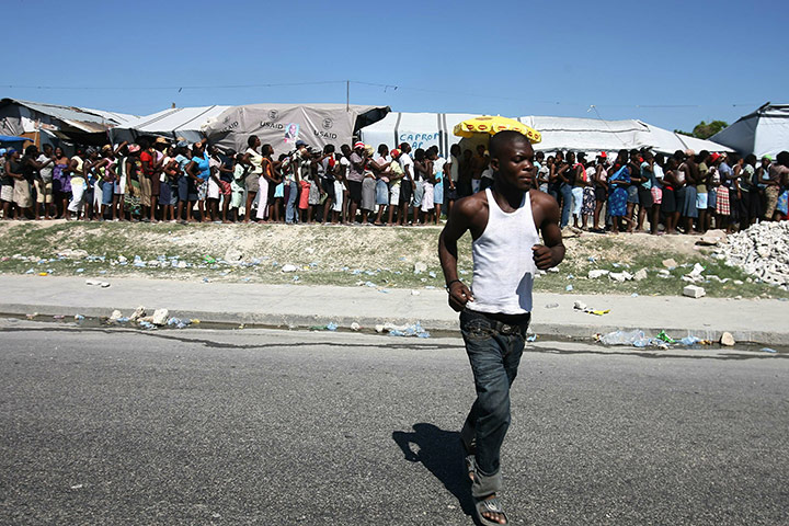 Haiti Cholera Devastation: Haitians line up to receive supplies from the Red Cross