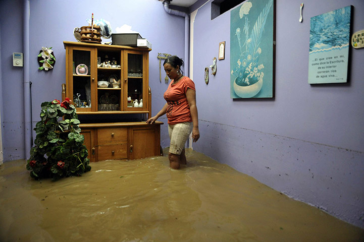 24 hours in pictures: A woman walks in her flooded house, Valle del Cauca, Colombia