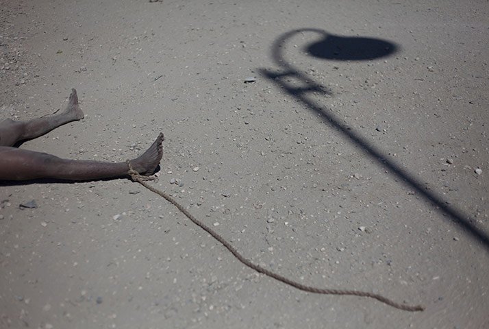24 hours in pictures: A man with a rope attached to his foot lies dead in the street, Haiti