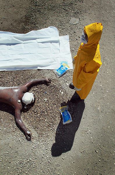 24 hours in pictures: A member of the Haitian Ministry of Health team sprays down a body, Haiti