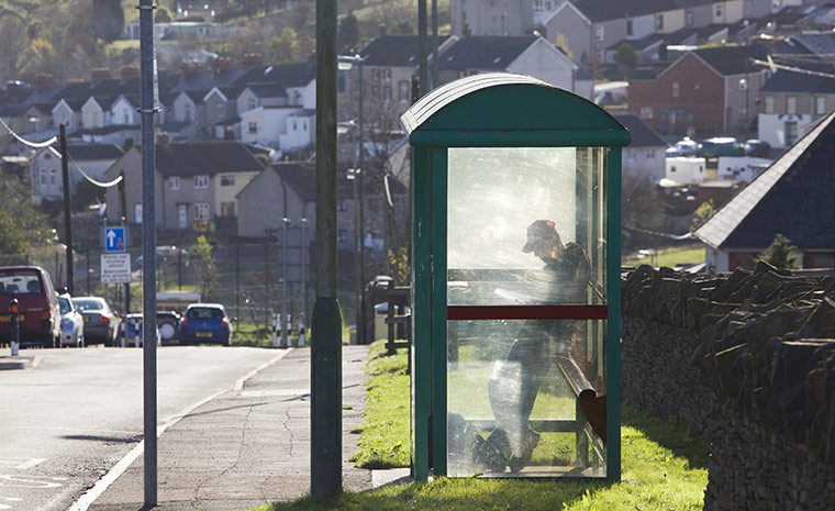 Spending Review 2010: A man waits at a bus stop in Fochriw village, Bargoed